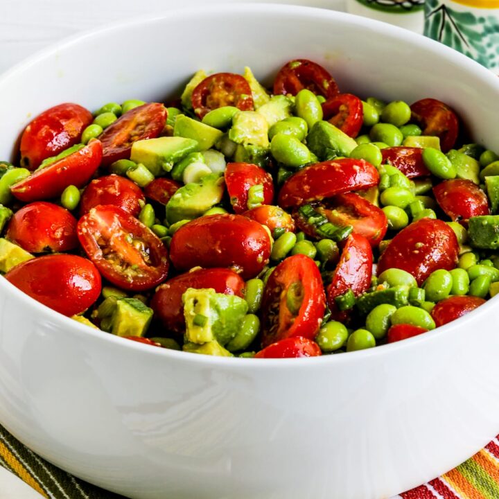 Tomato Avocado Salad with Edamame shown in large serving bowl with serving fork.