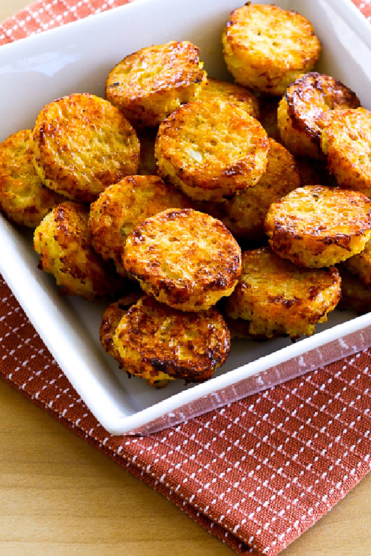 Easy Baked Cauliflower Tots in square bowl on rust colored napkin