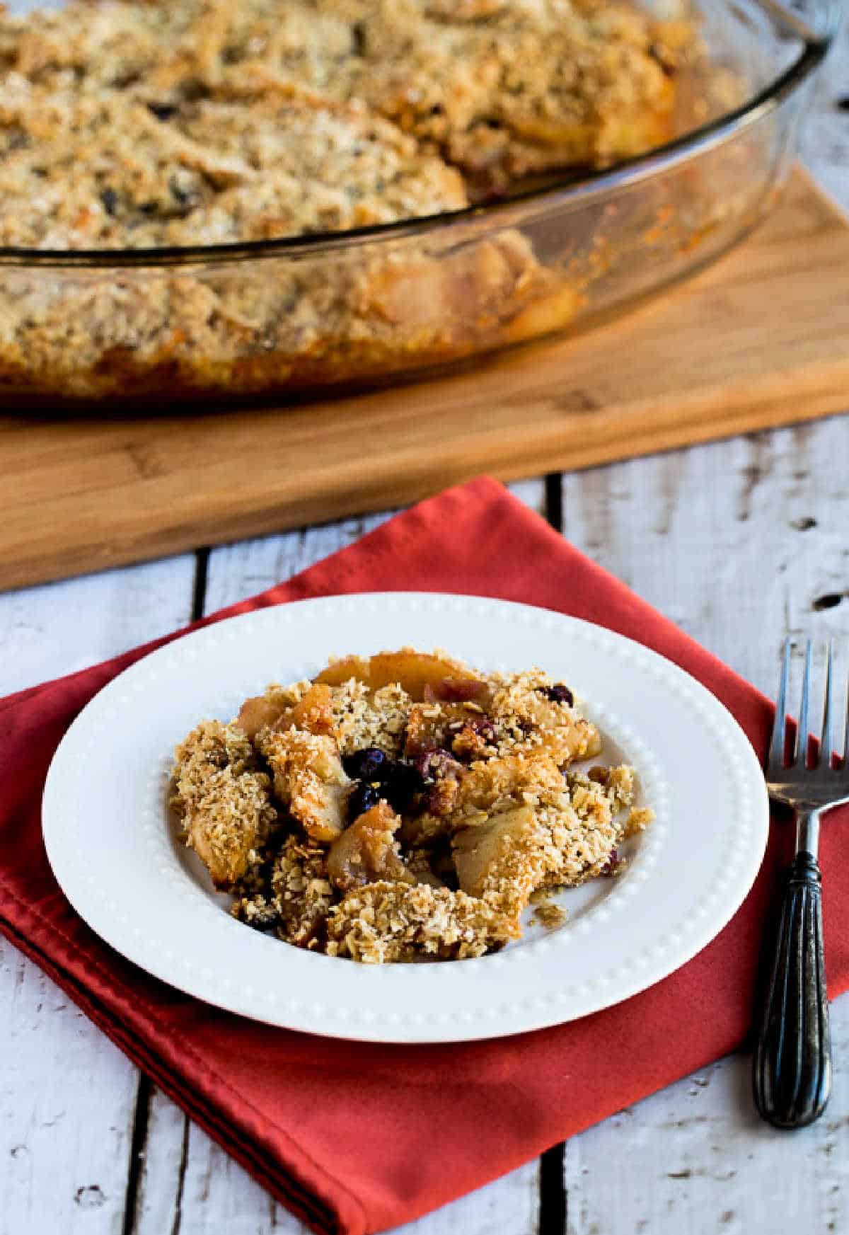 Cranberry Apple Crumble in baking dish with one serving on plate