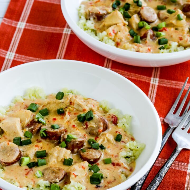 close-up of Chicken and Sausage Stew shown in two serving bowls and served over cauliflower rice