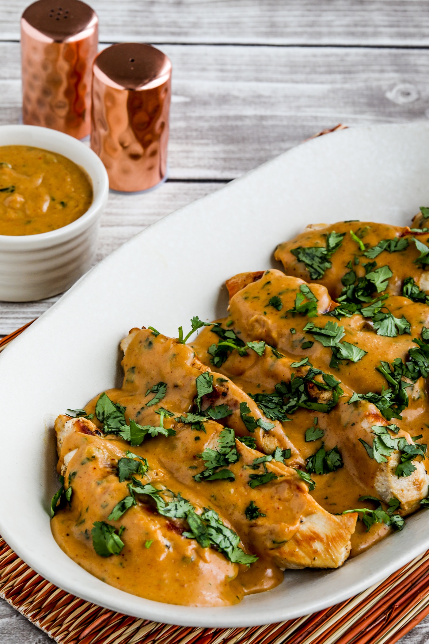 Chicken with Peanut Sauce shown on serving plate with sauce on side