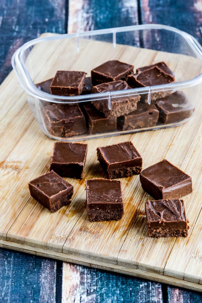 Peanut Butter Fudge on cutting board with container of fudge in background