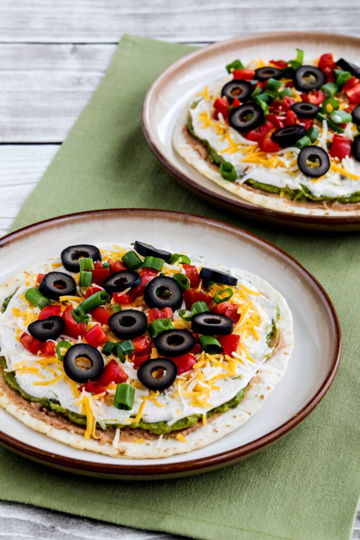 Seven Layer Dip Tostadas shown on serving plates