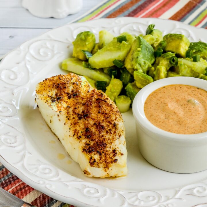 Spicy Air Fryer Fish shown on plate with avocado salad and remoulade sauce