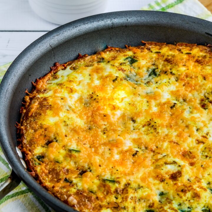 close-up photo of Zucchini Frittata shown in frittata pan with sour cream on the side