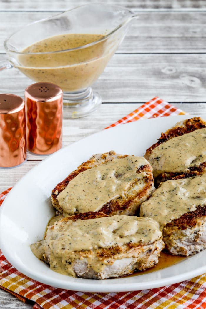 Grain-Free Breaded Pork Chops show on plate with gravy boat in background