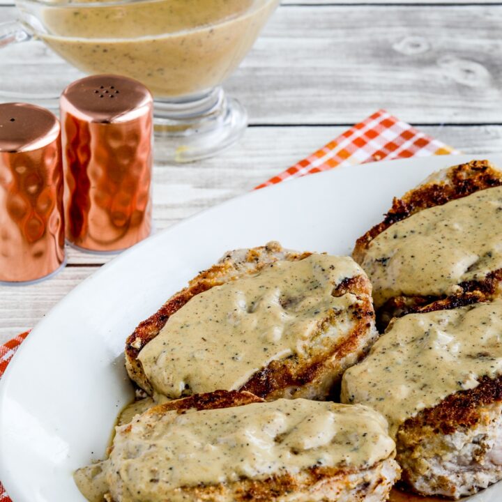 Grain-Free Breaded Pork Chops show on plate with gravy boat in background