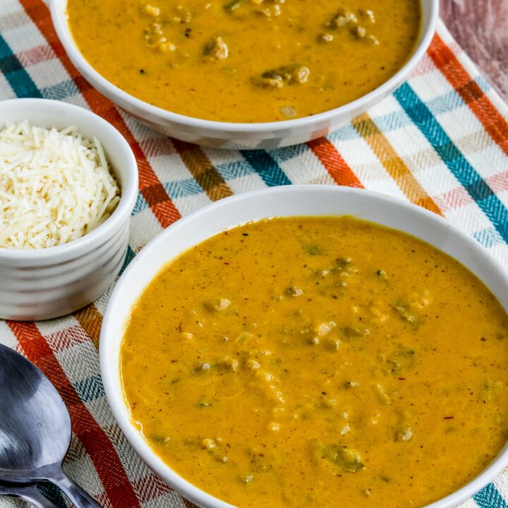 Instant Pot Pumpkin Soup in two serving bowls with spoons and Parmesan cheese