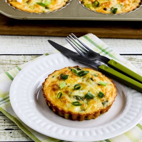 Cheesy Zucchini Breakfast Tarts shown on plate with tart pan in background