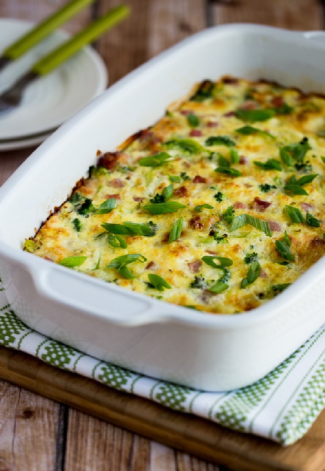 Broccoli, Ham, and Mozzarella Baked with Eggs finished casserole in baking dish with plates in background