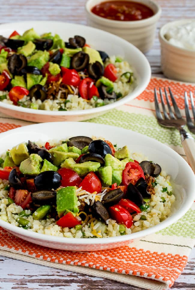 Ground Beef Cauliflower Rice Taco Bowls with two bowls and toppings.