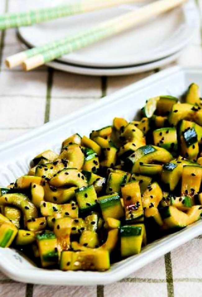 Chinese Cucumber Salad on serving platter with plates and chopsticks.