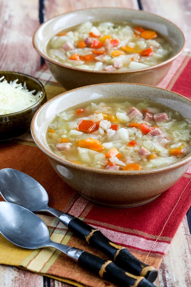 Instant Pot Ham and Cabbage Soup shown in two soup bowls with spoons and napkin