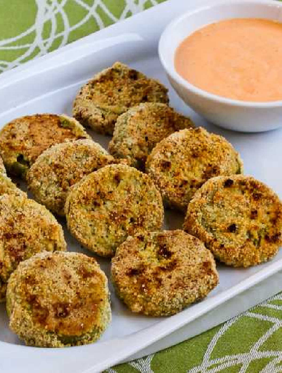 Oven-Fried Green Tomatoes with Sriracha-Ranch Dipping Sauce shown on serving plate with sauce