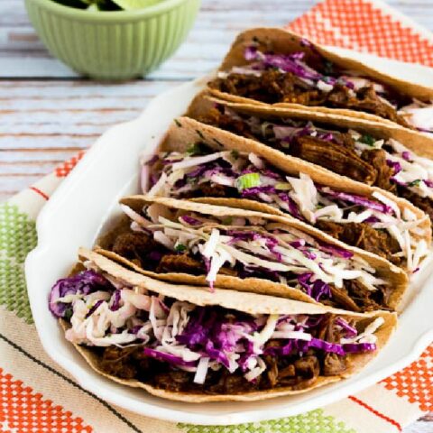 Flank Steak Tacos on plate served with spicy Mexican Slaw and lime wedges