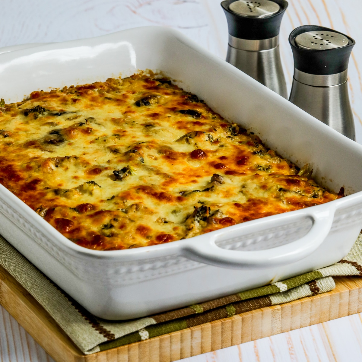 Square image for Cheesy Vegetarian Casserole (with Cauliflower Rice) shown in baking dish with salt and pepper on the side.