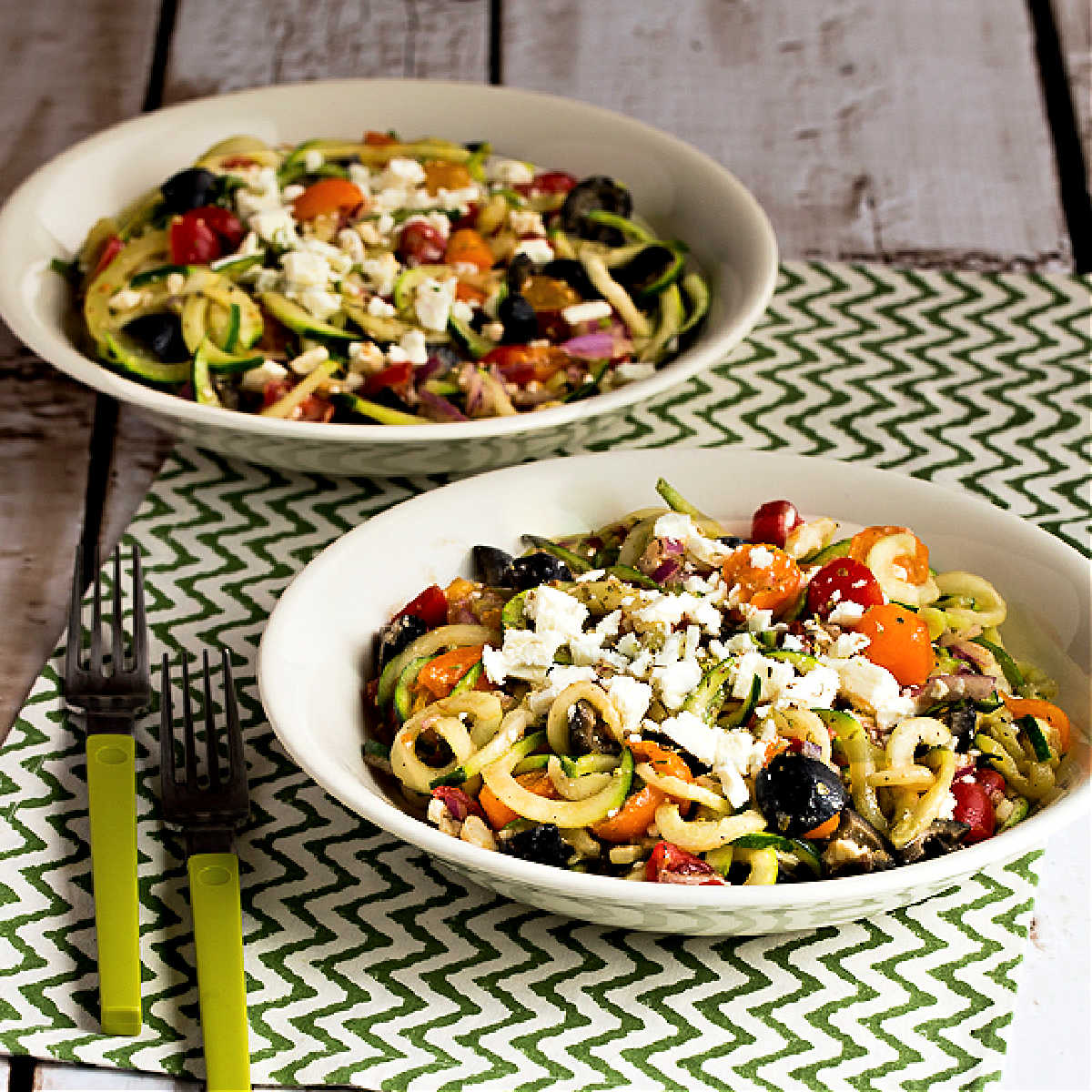 Greek-Style Zucchini Noodles shown in two serving bowls.