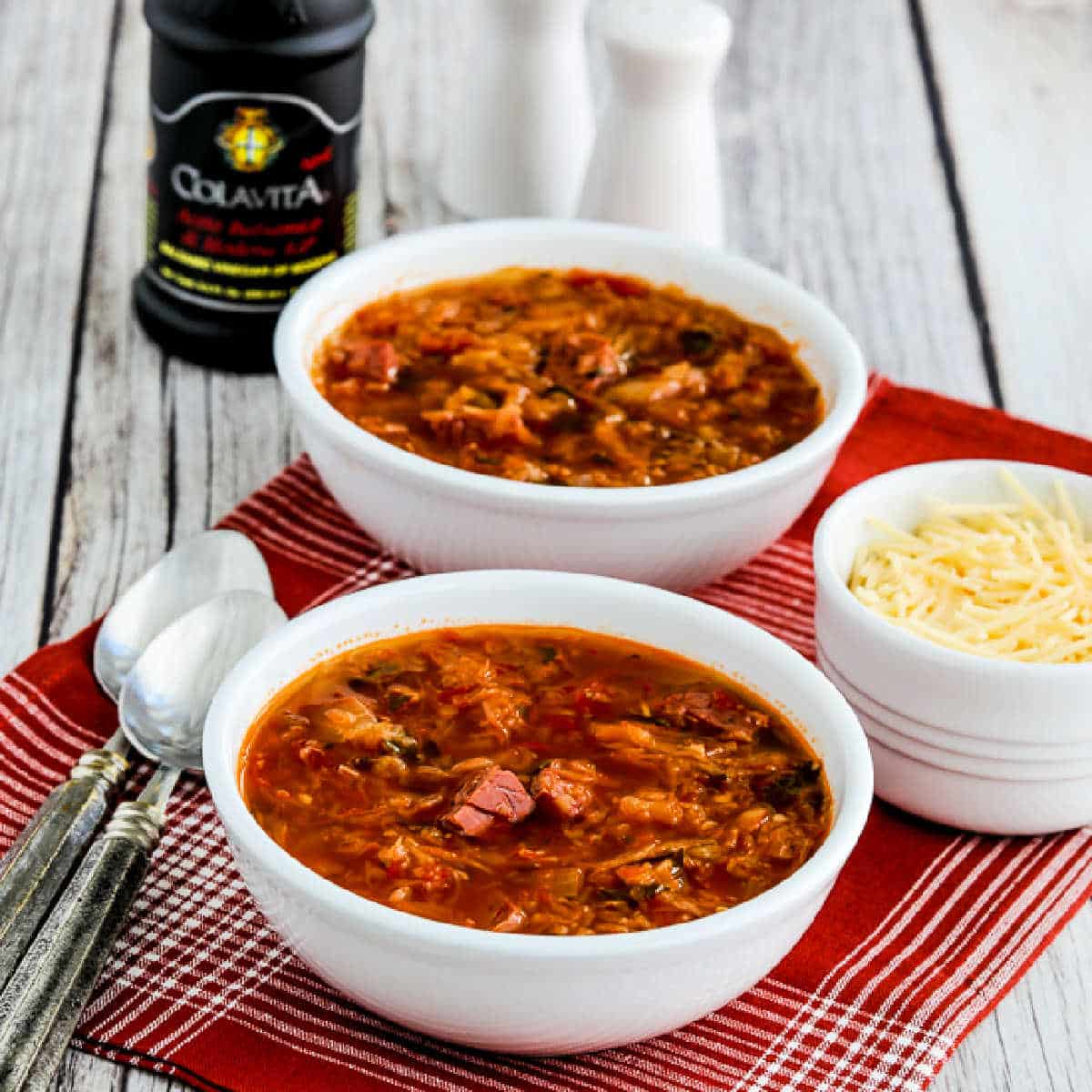 Square image of Leftover Corned Beef Soup in two serving bowls with cheese and balsamic vinegar.