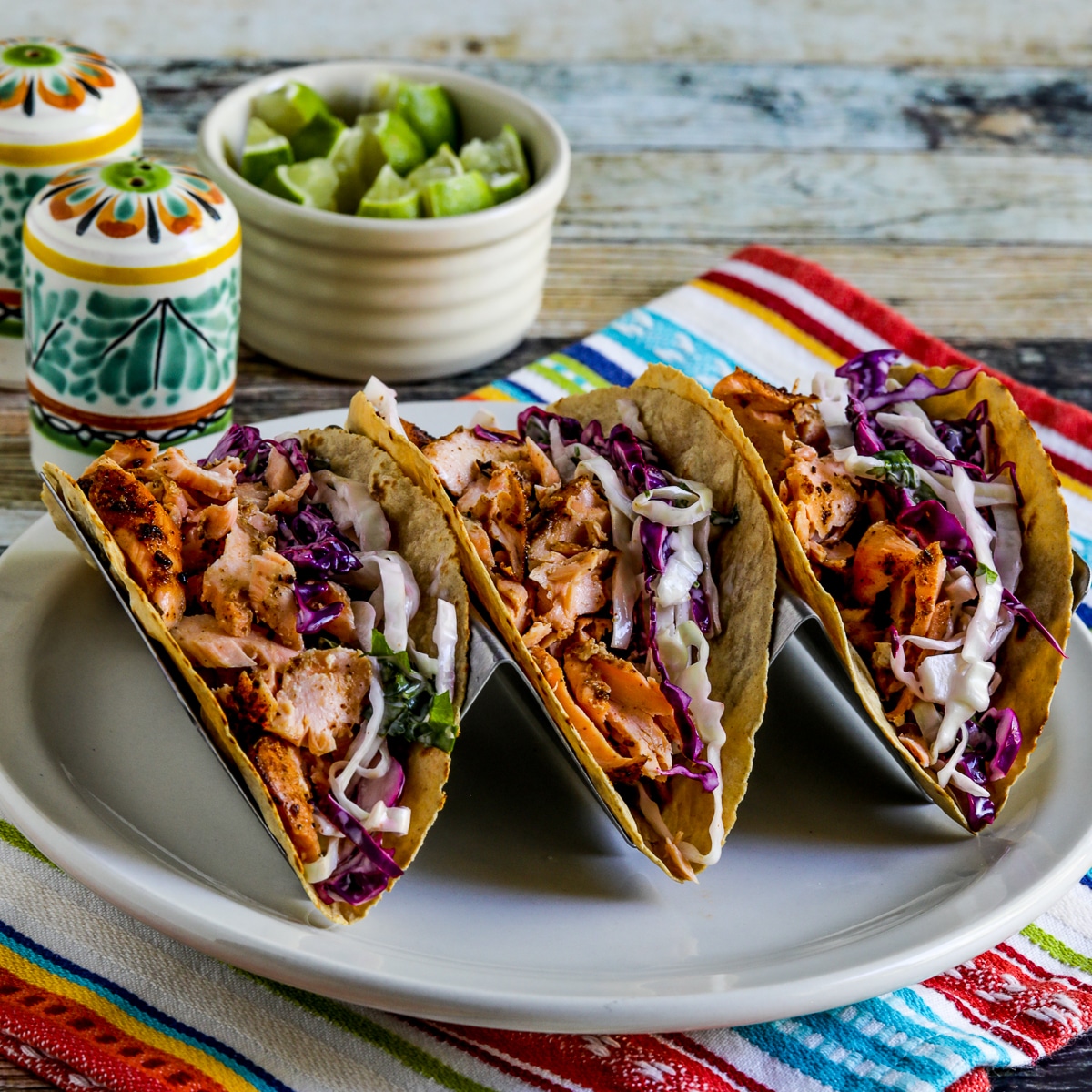 square image of Salmon Tacos with Mexican Slaw in taco holder on plate