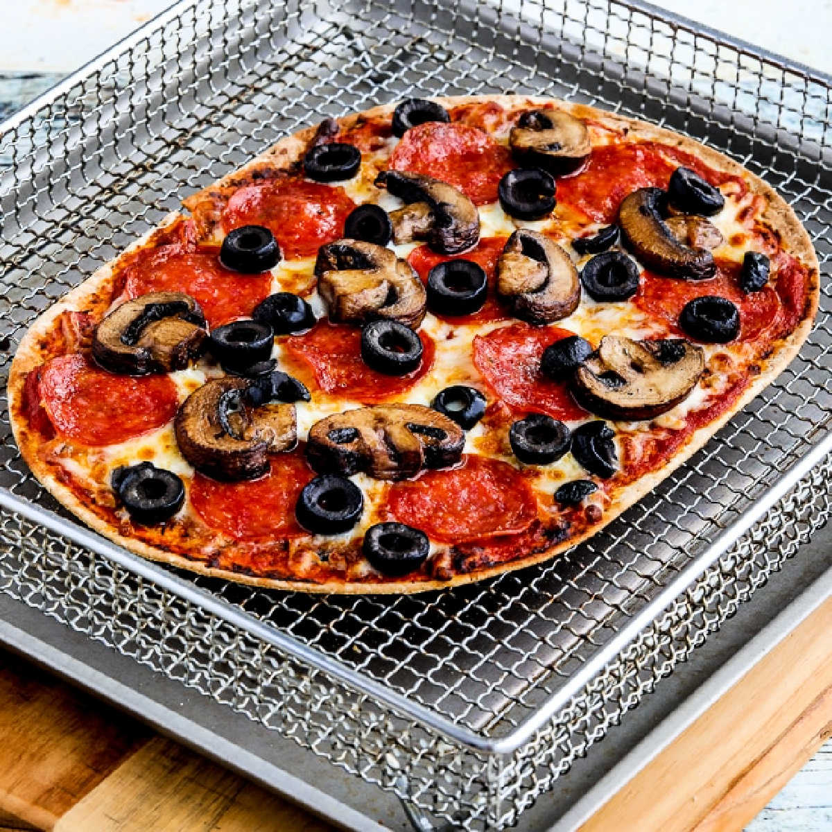 Air Fryer Pizza shown in Air Fryer basket.