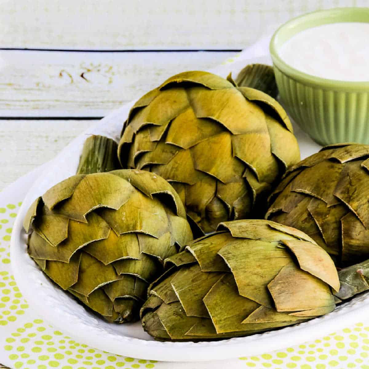 Artichokes shown on serving plate with Artichoke Dipping Sauce