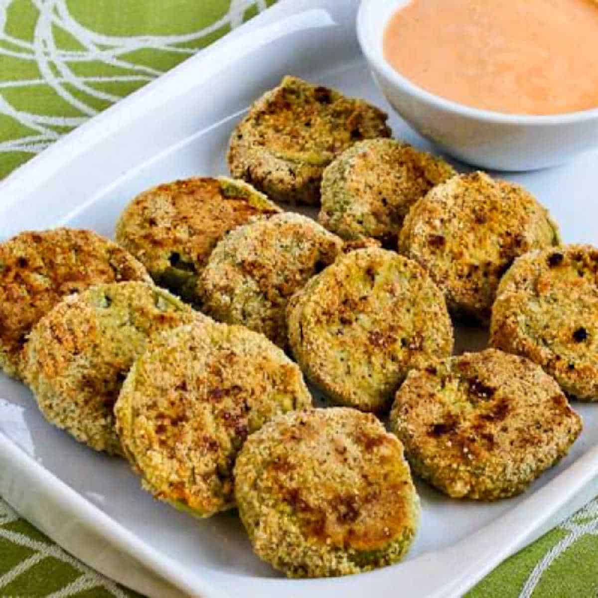 square image of Oven-Fried Green Tomatoes with Sriracha-Ranch Dipping Sauce on serving plate with sauce