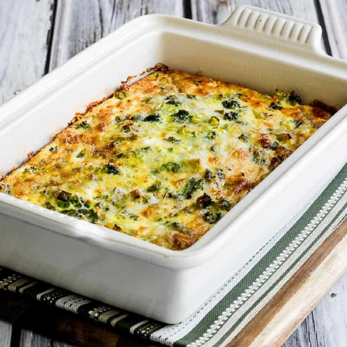 Square image for Broccoli and Three Cheese Keto Breakfast Casserole shown in baking dish on cutting board.