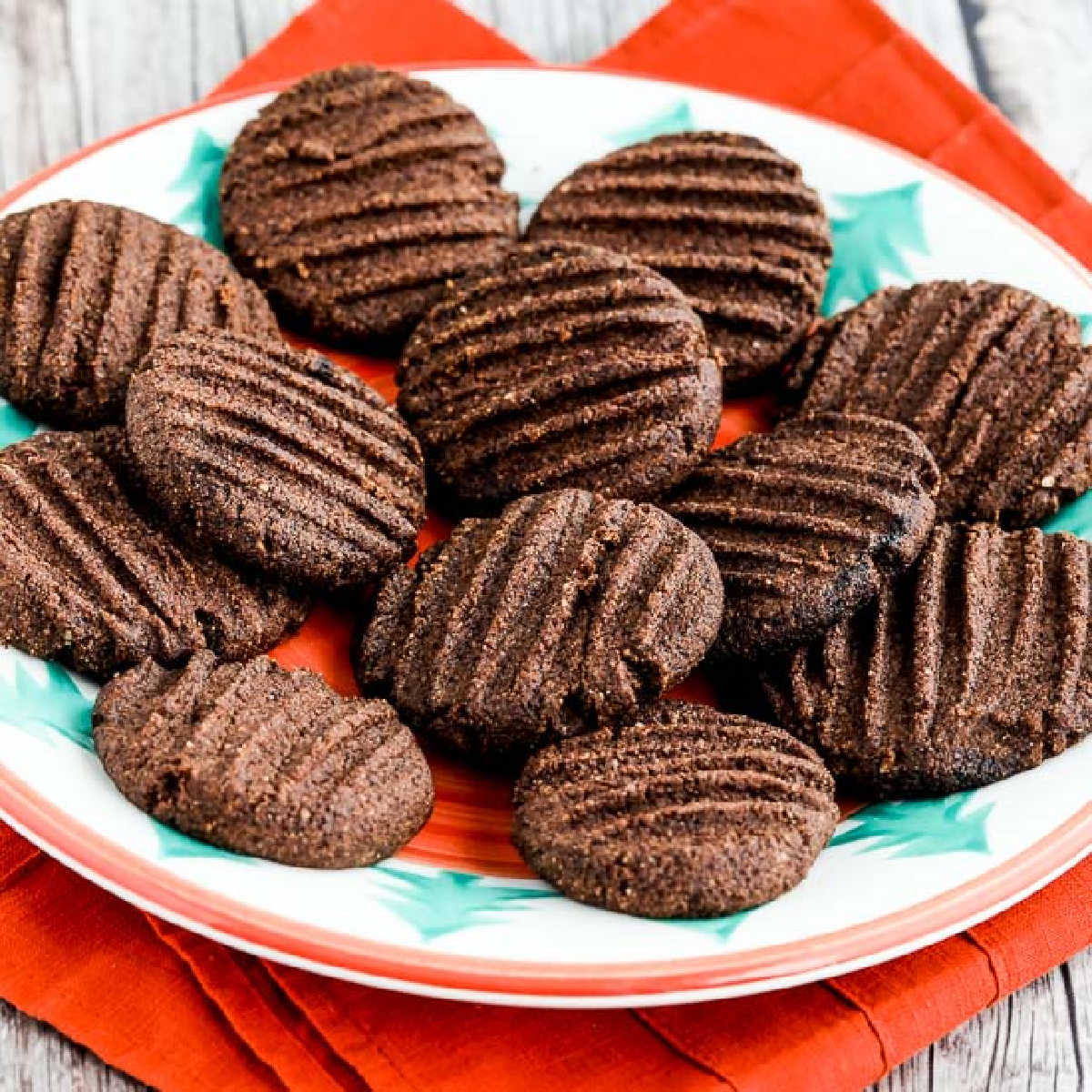 Flourless Sugar-Free Chocolate Cookies shown on plate with red napkin, square image