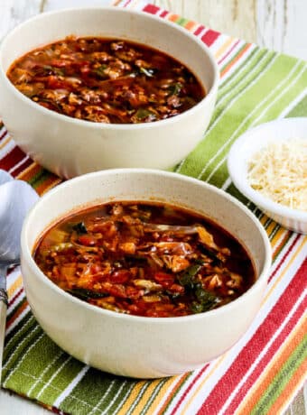 Square image for Ground Beef Vegetable Soup shown in two bowls with Parmesan cheese.