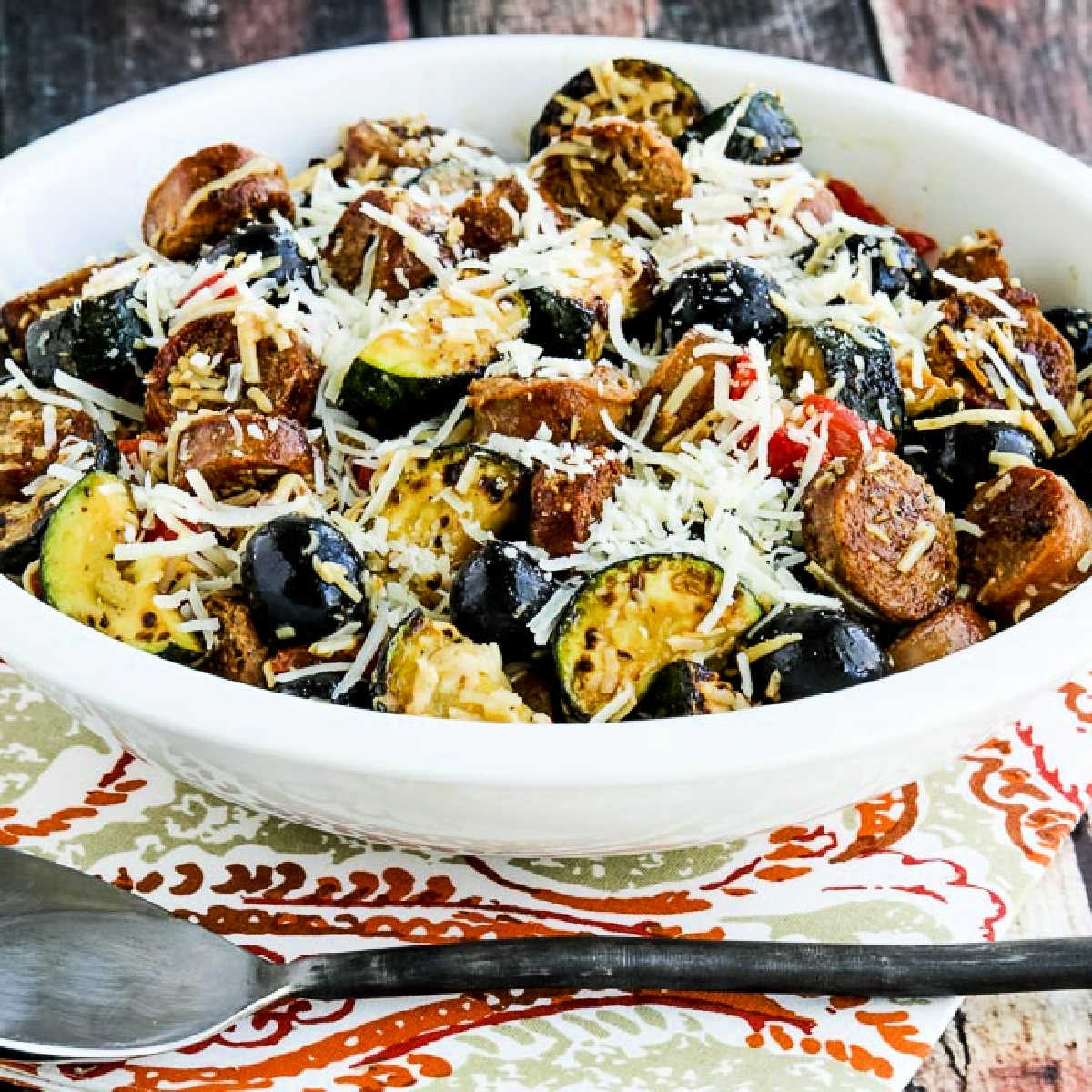 Square image of No-Pasta Salad with Zucchini and Italian Sausage shown in serving bowl.