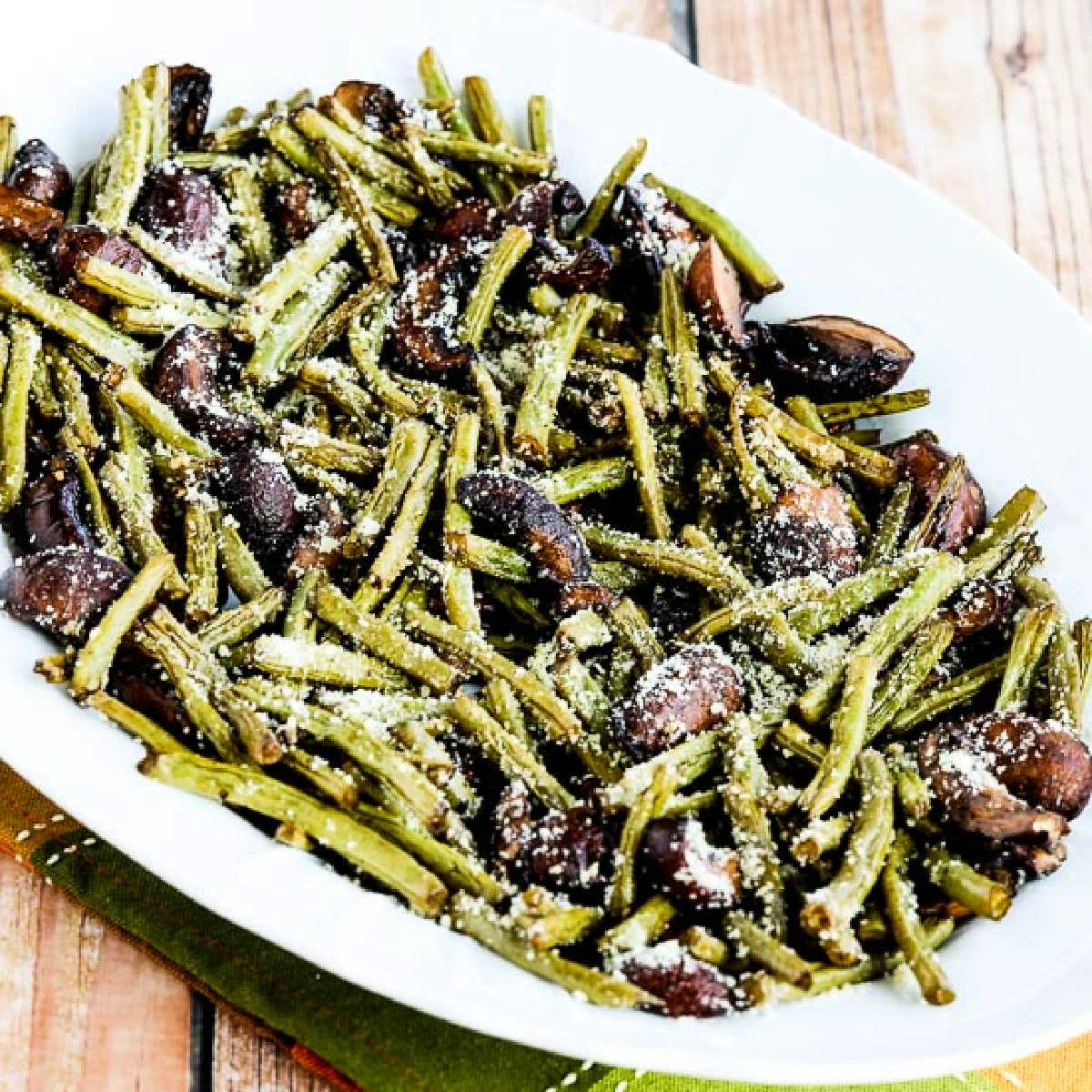 Square image of Roasted Green Beans with Mushrooms, Balsamic, and Parmesan shown on serving platter.