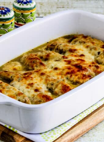 Square image of Salsa Verde Chicken Bake shown in baking dish with Mexican salt-pepper shakers in background.