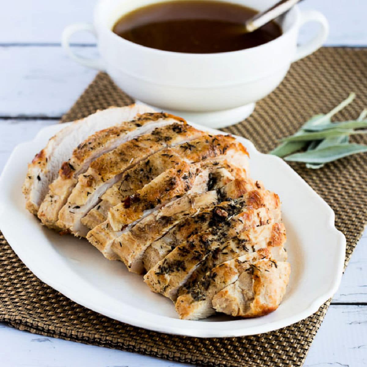 Square image of Slow Cooker Turkey Breast shown on platter with gravy in back.