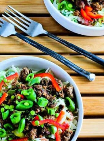 Square image for Sriracha Beef Cabbage Bowls shown in two bowls with forks.