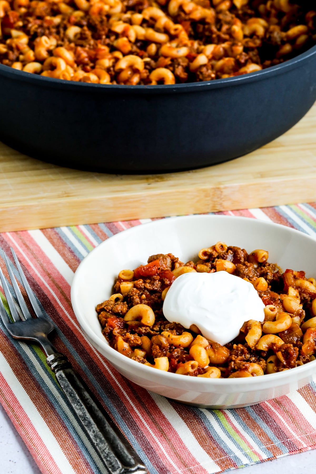 Lower-Carb Hamburger Goulash shown in one bowl with pan in back.