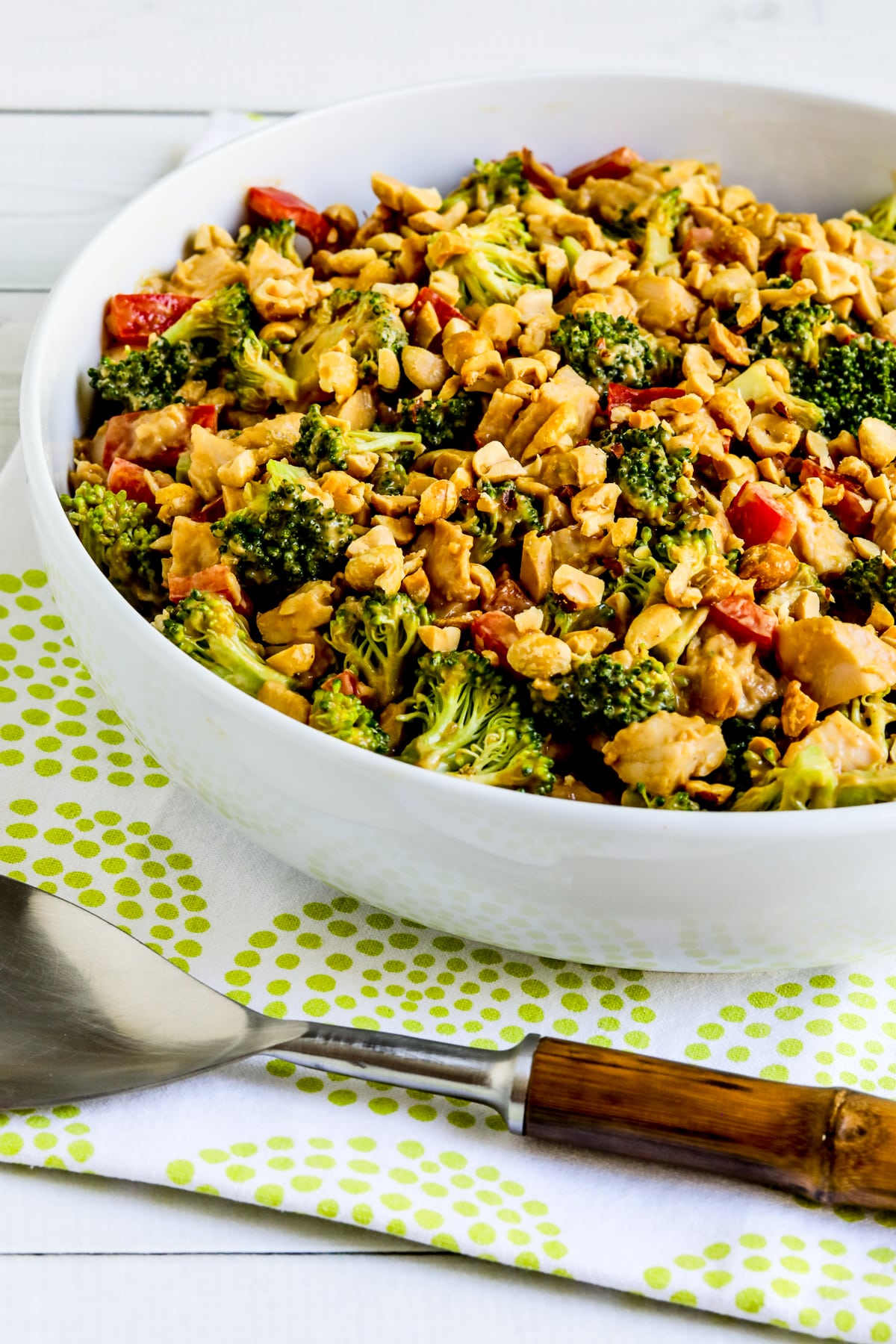 Chicken Broccoli Salad in serving bowl on green-white napkin.