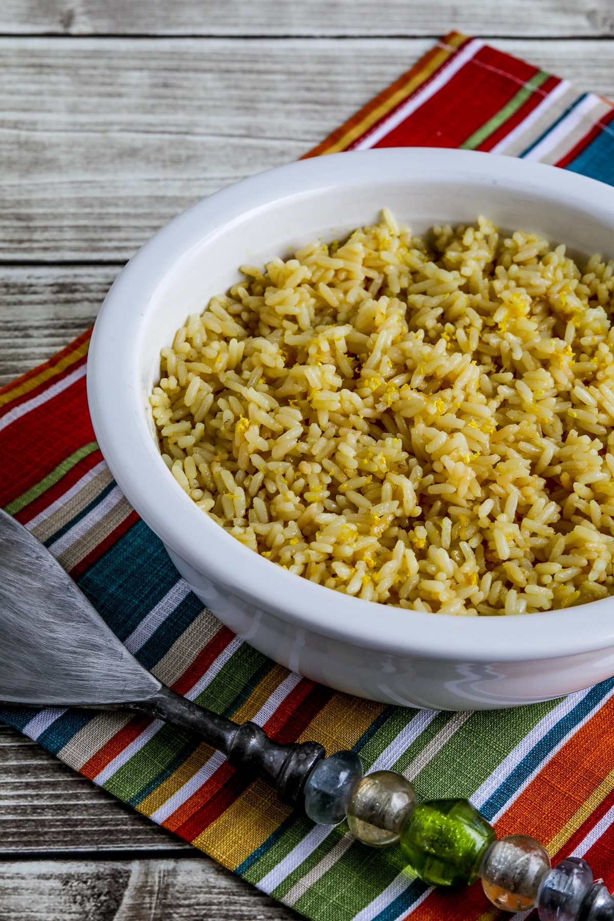 Close photo of Greek Lemon Rice shown in bowl with serving spoon.