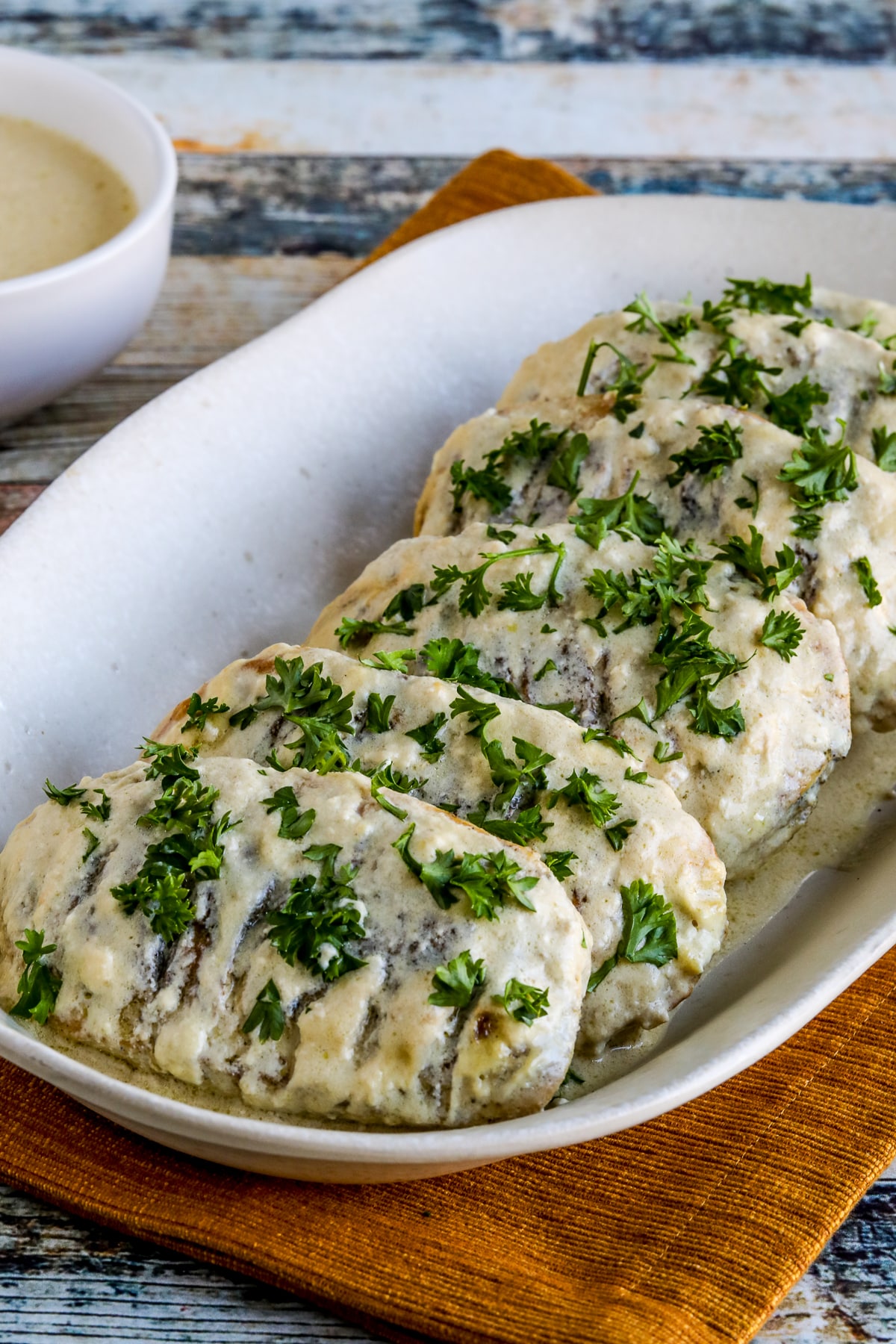 Janet's Easy Mustard Chicken on serving plate with extra sauce in small bowl.