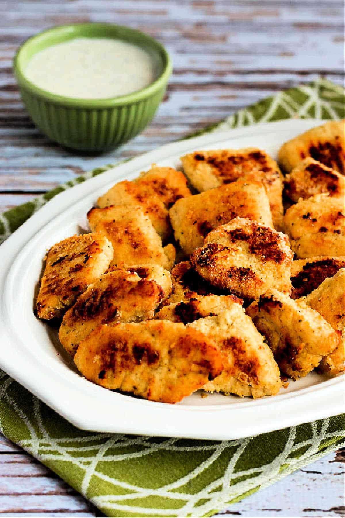 finished chicken nuggets shown on serving plate with Ranch in background