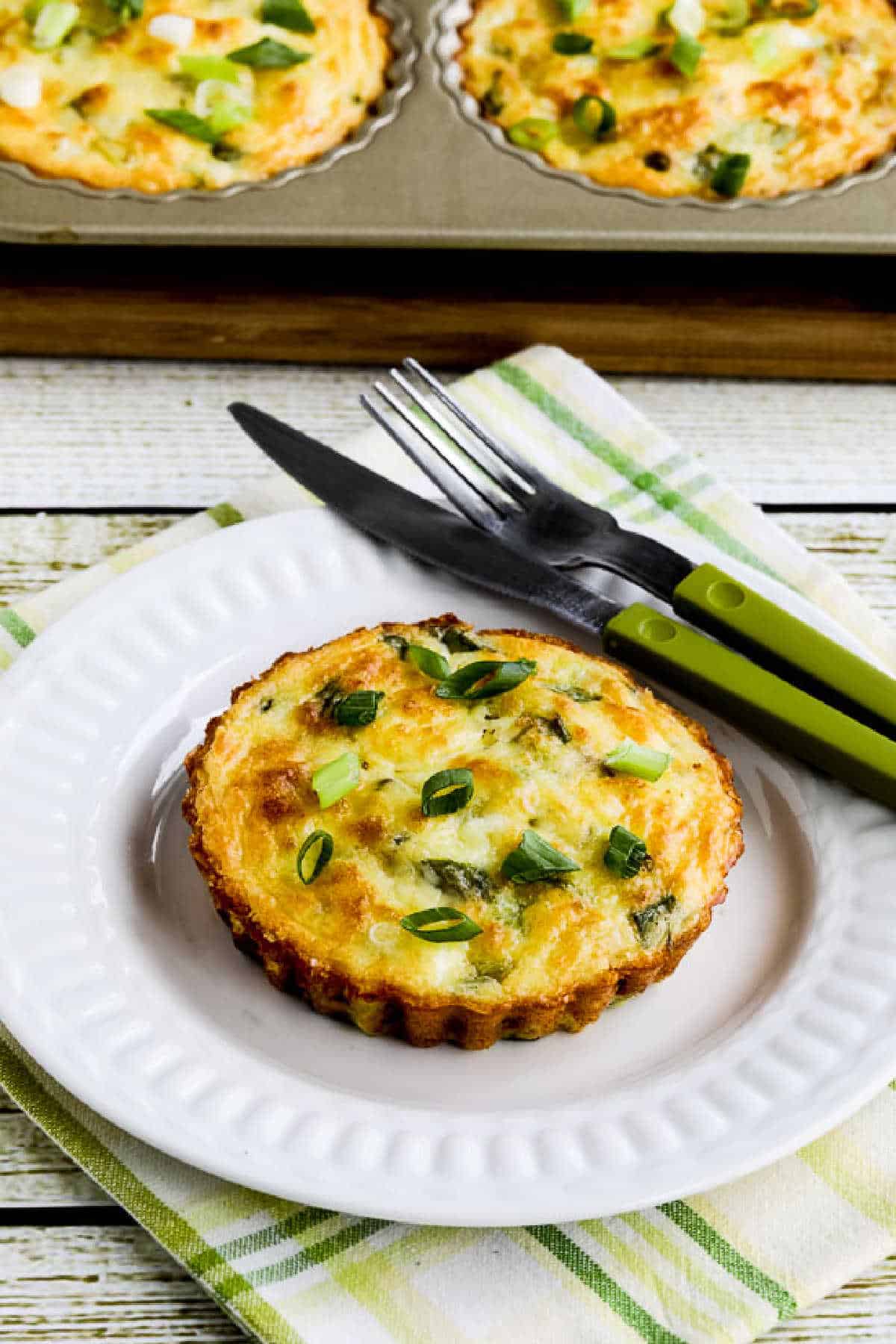 Zucchini Breakfast Tarts with one on serving plate and tart pan in background