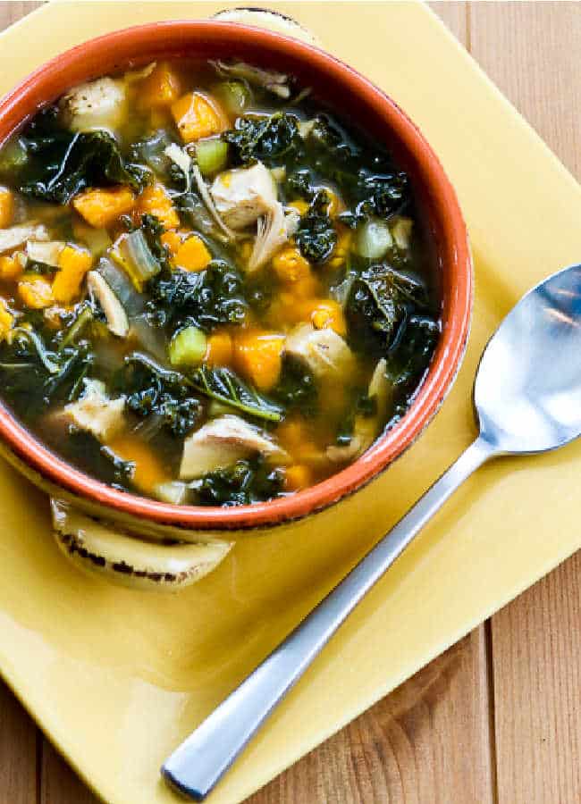 Slow Cooker Turkey Soup with Kale and Sweet Potatoes with soup in bowl on yellow plate