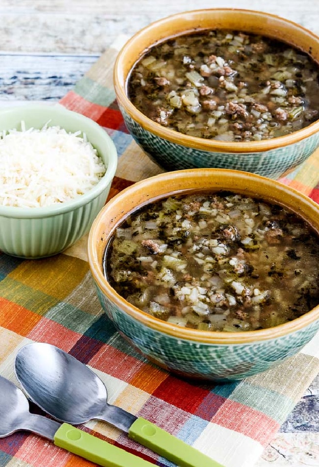 Instant Pot Low-Carb Ground Beef Cauliflower Soup shown in two soup bowls with Parmesan cheese on the side