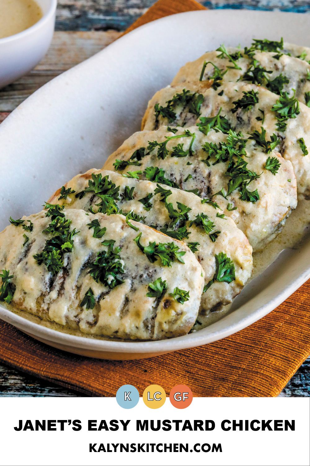 Pinterest image for Janet's Easy Mustard Chicken shown on serving plate with parsley garnish and extra sauce in back.